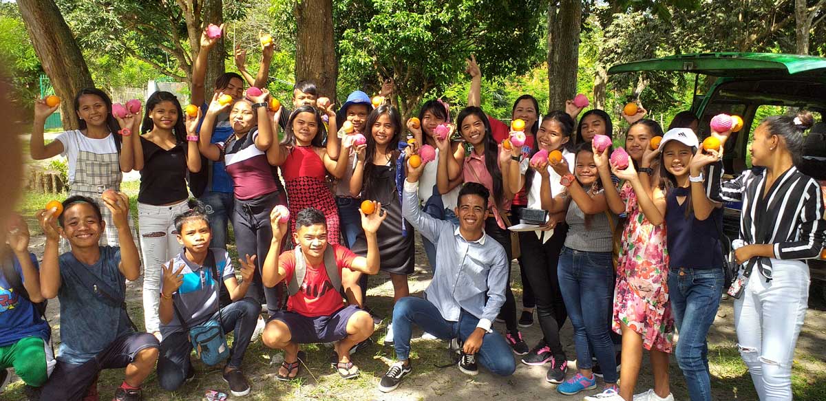 Group of youth holding oranges