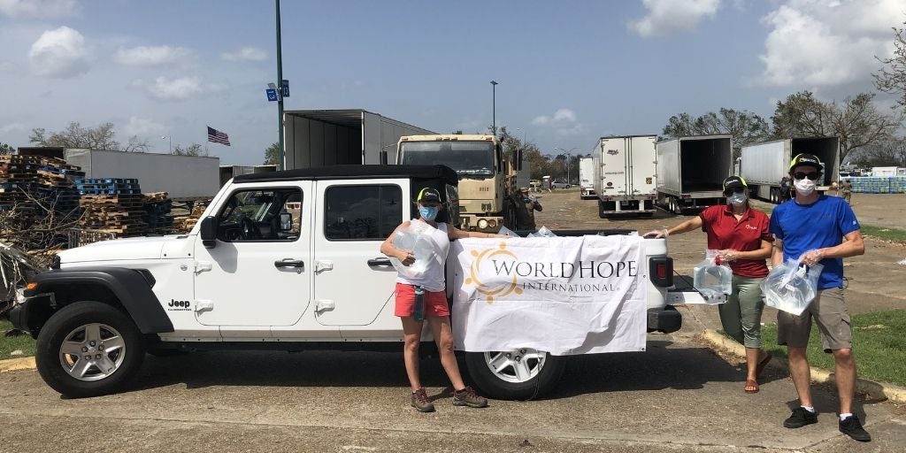 World Hope Workers carrying water sachets