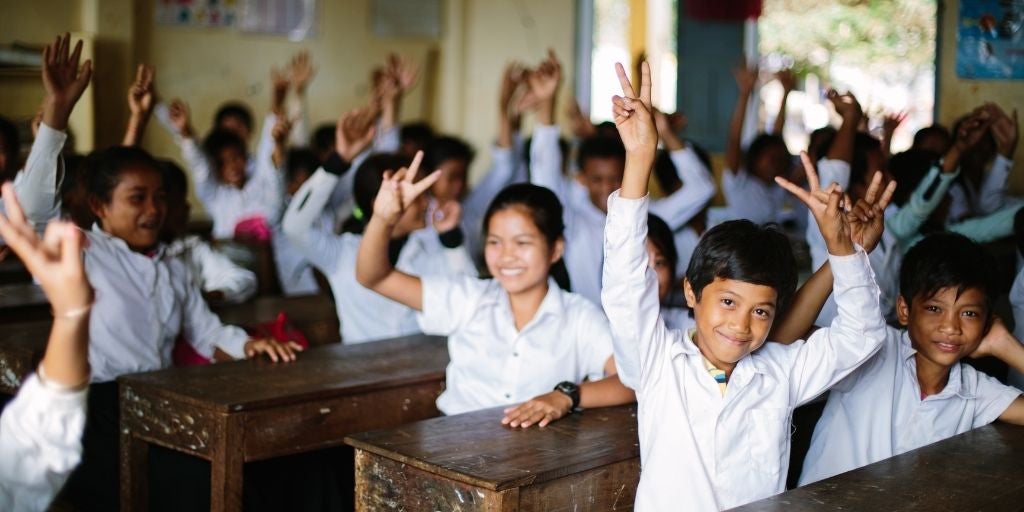 Children giving the peace sign in school