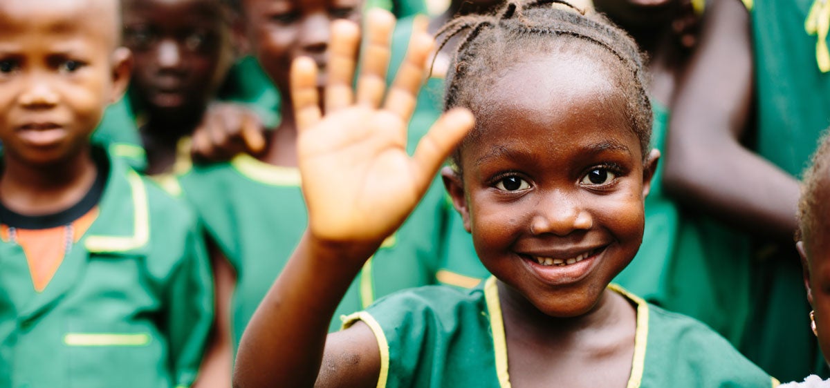 Little girl waving in school uniform