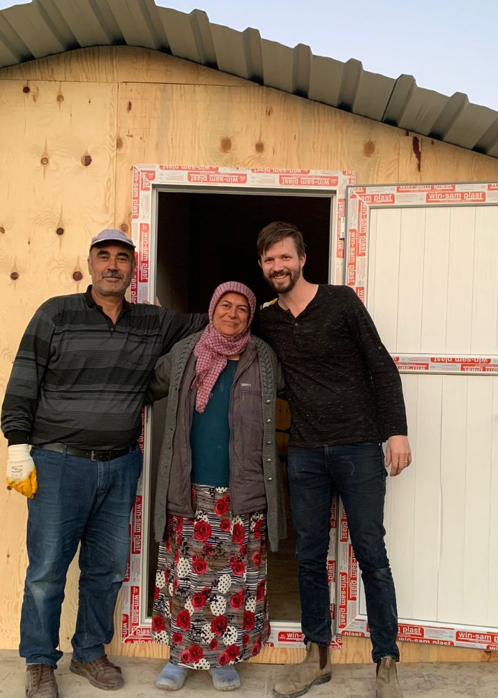 Survivor in front of newly build shelter