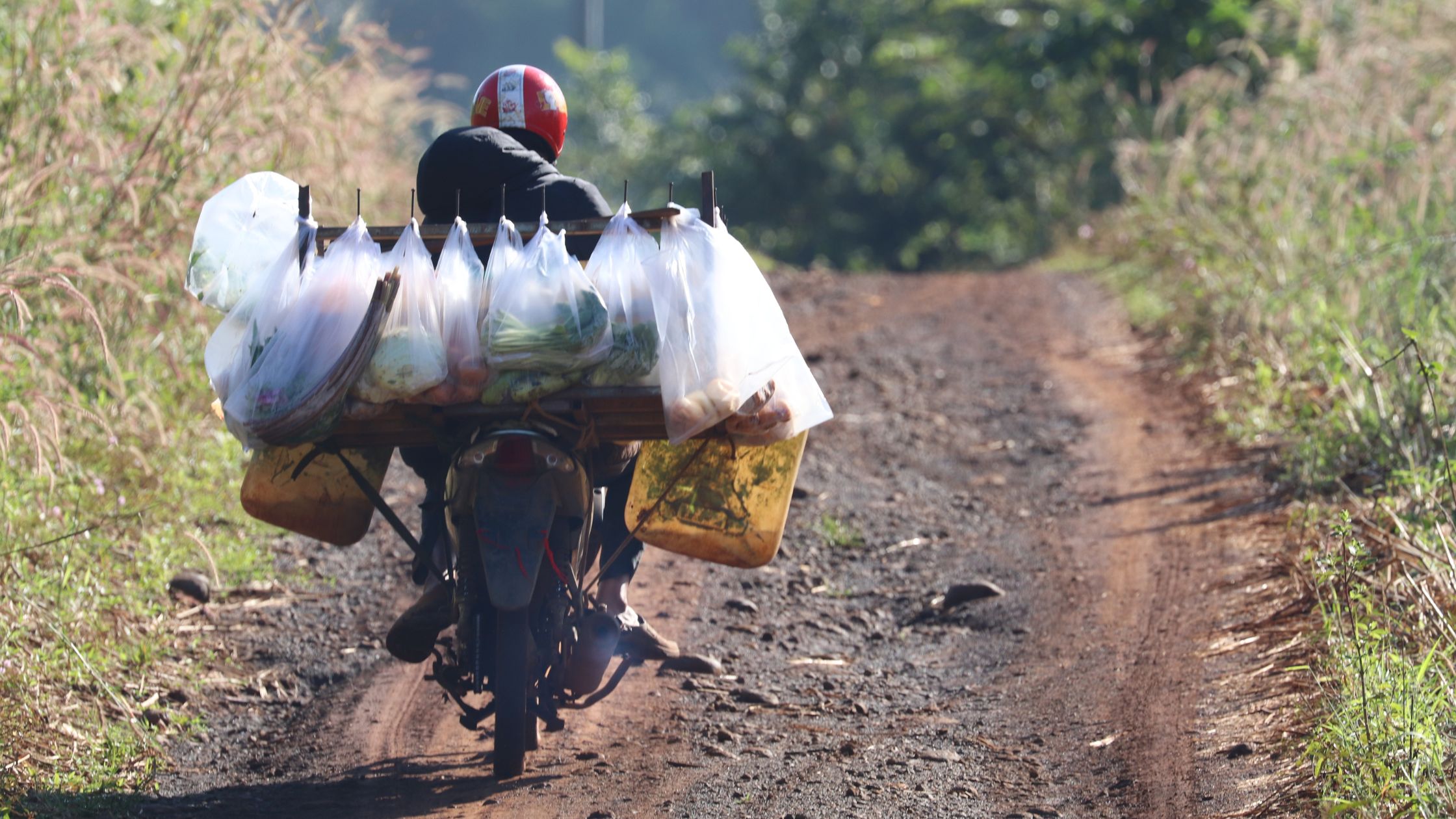 A person riding motorbike to collect water