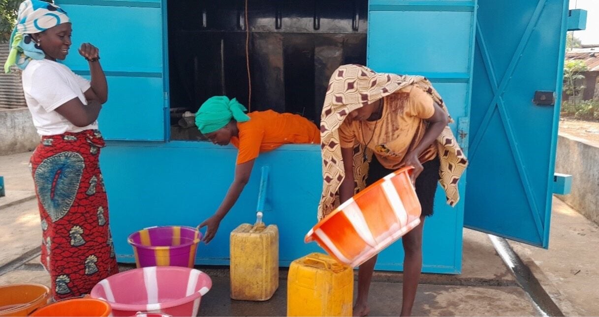 Women collecting water at a kiosk in Sierra Leone