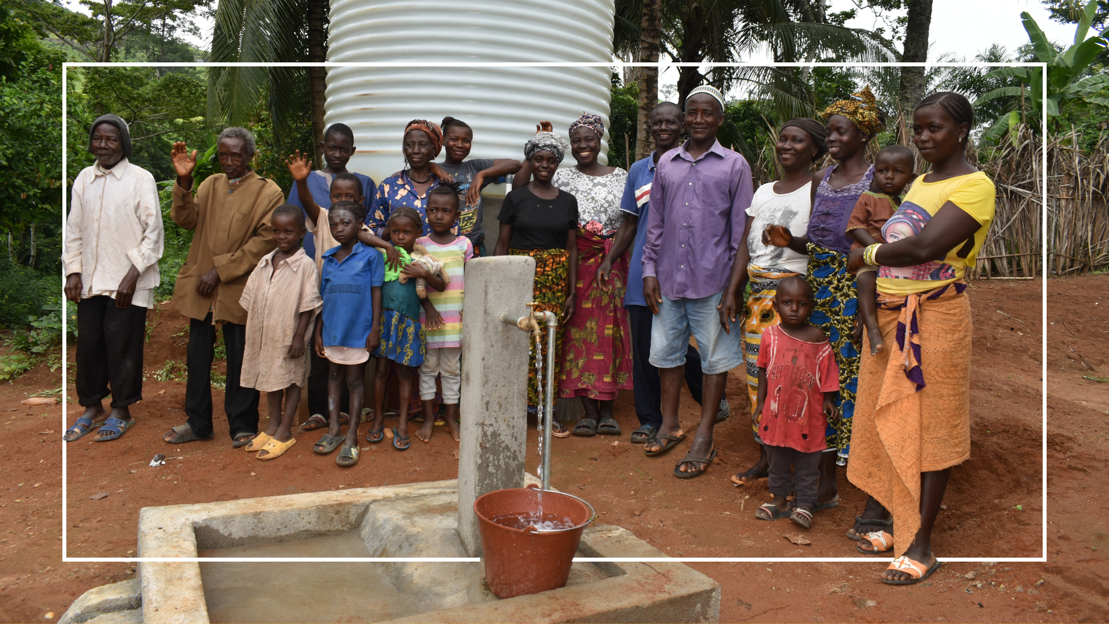 Community standing in front of gravity-fed water system