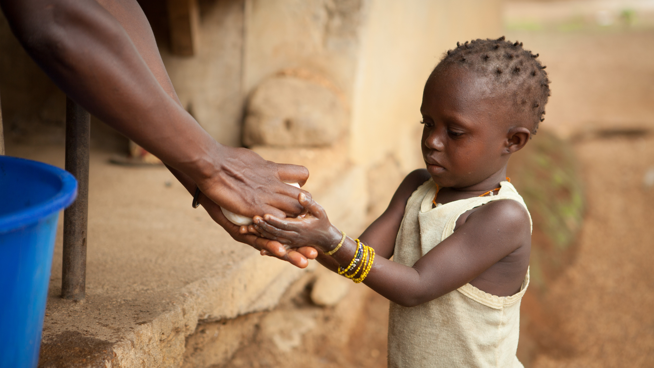 Child receiving help washing their hands