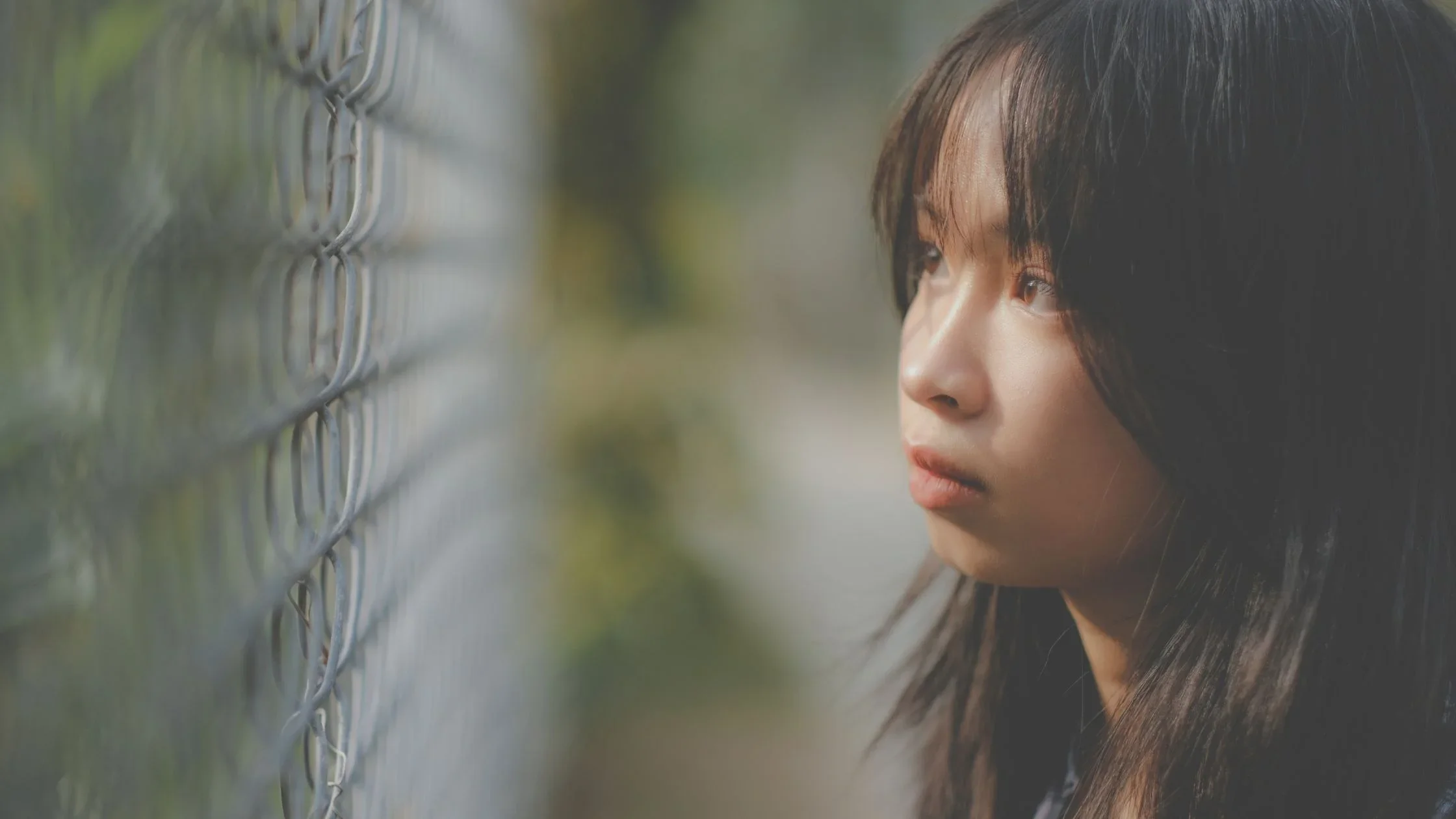 Filipino girl looking at a fence