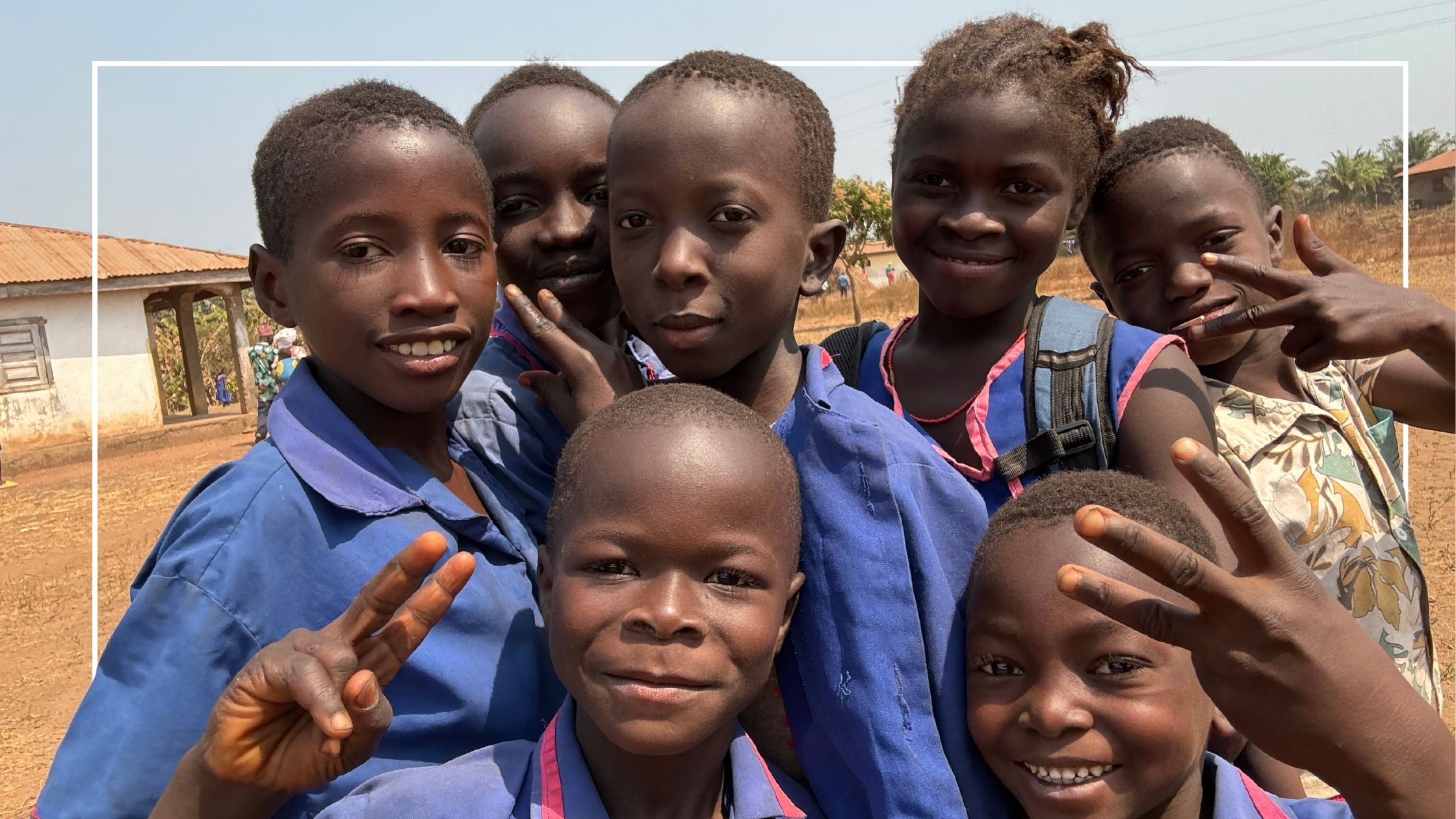 Children smiling making the peace sign