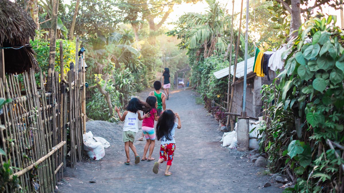 Filipino children running up a road
