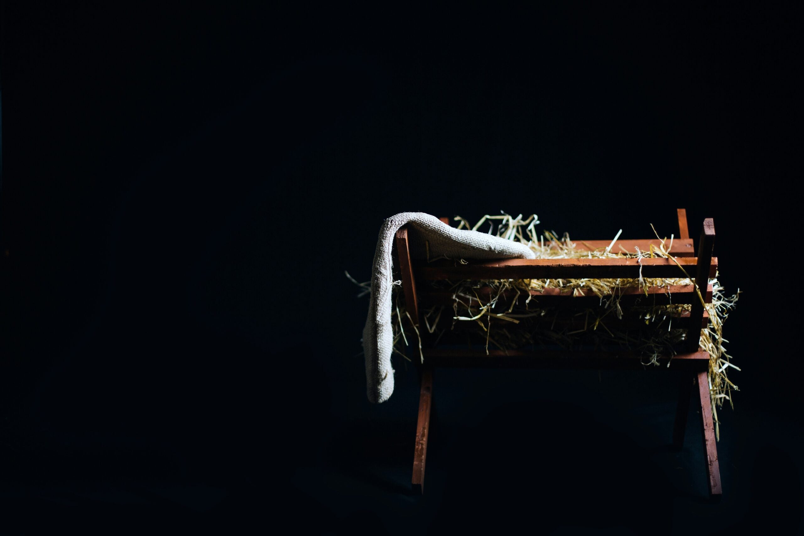 jon-carlson-nXow0r783Gg-unsplash manger filled with hay on a black background