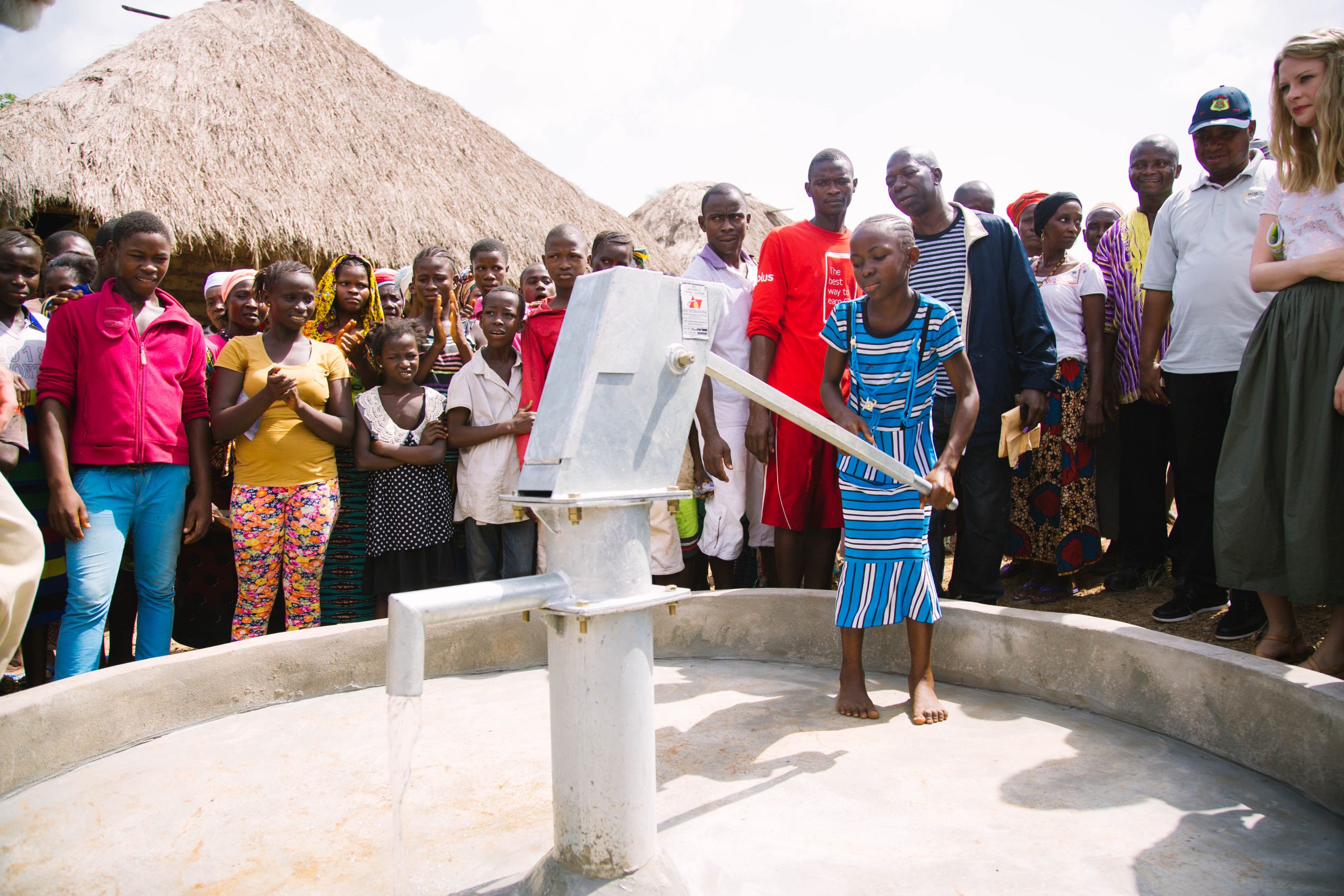 Girl pumping clean water from deep borehole well