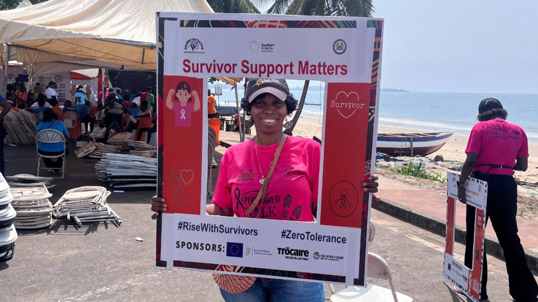 an African woman holding a frame that says survivor support matters