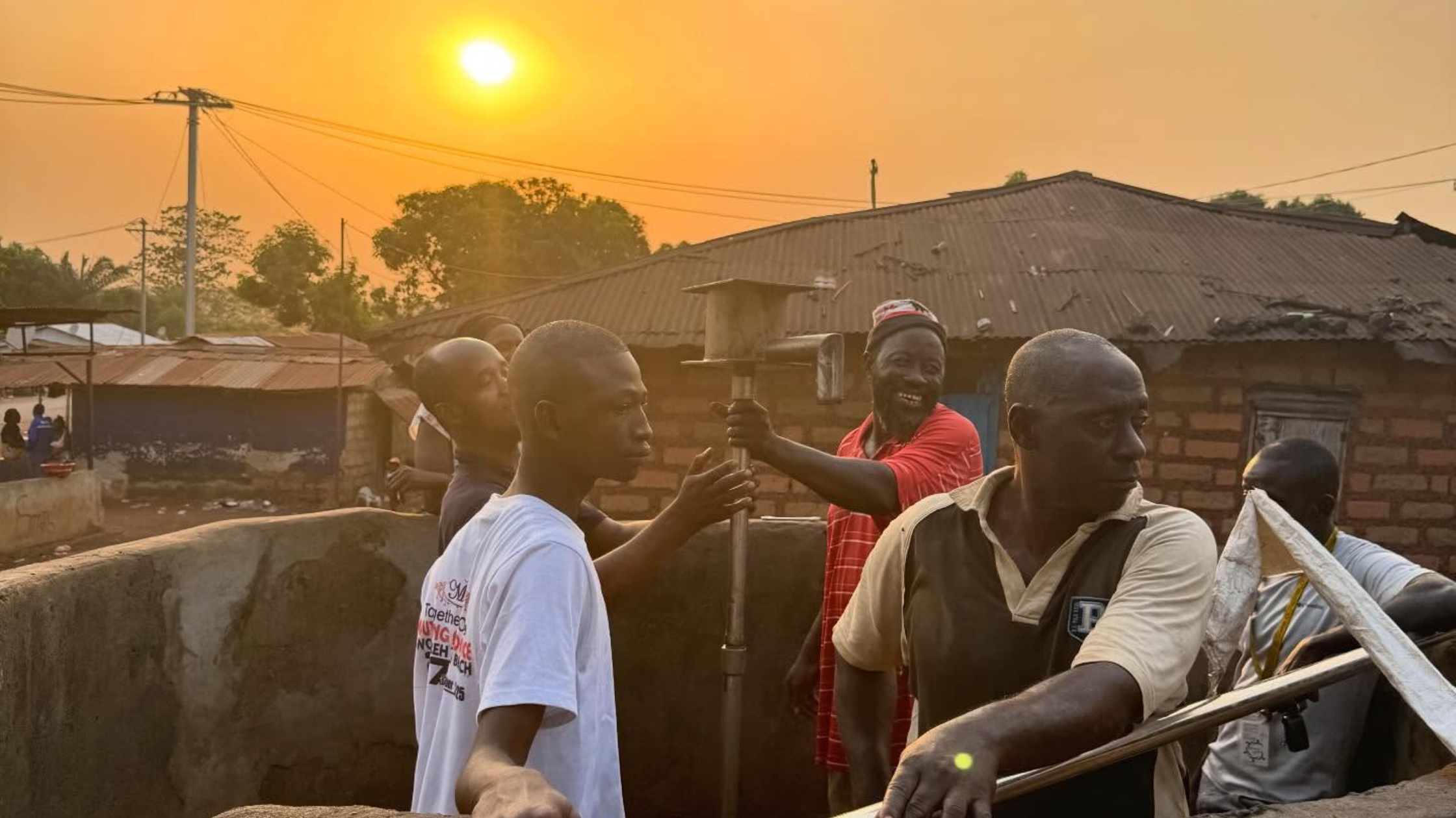 Team fixing pump for a deep borehole well as the sun is setting